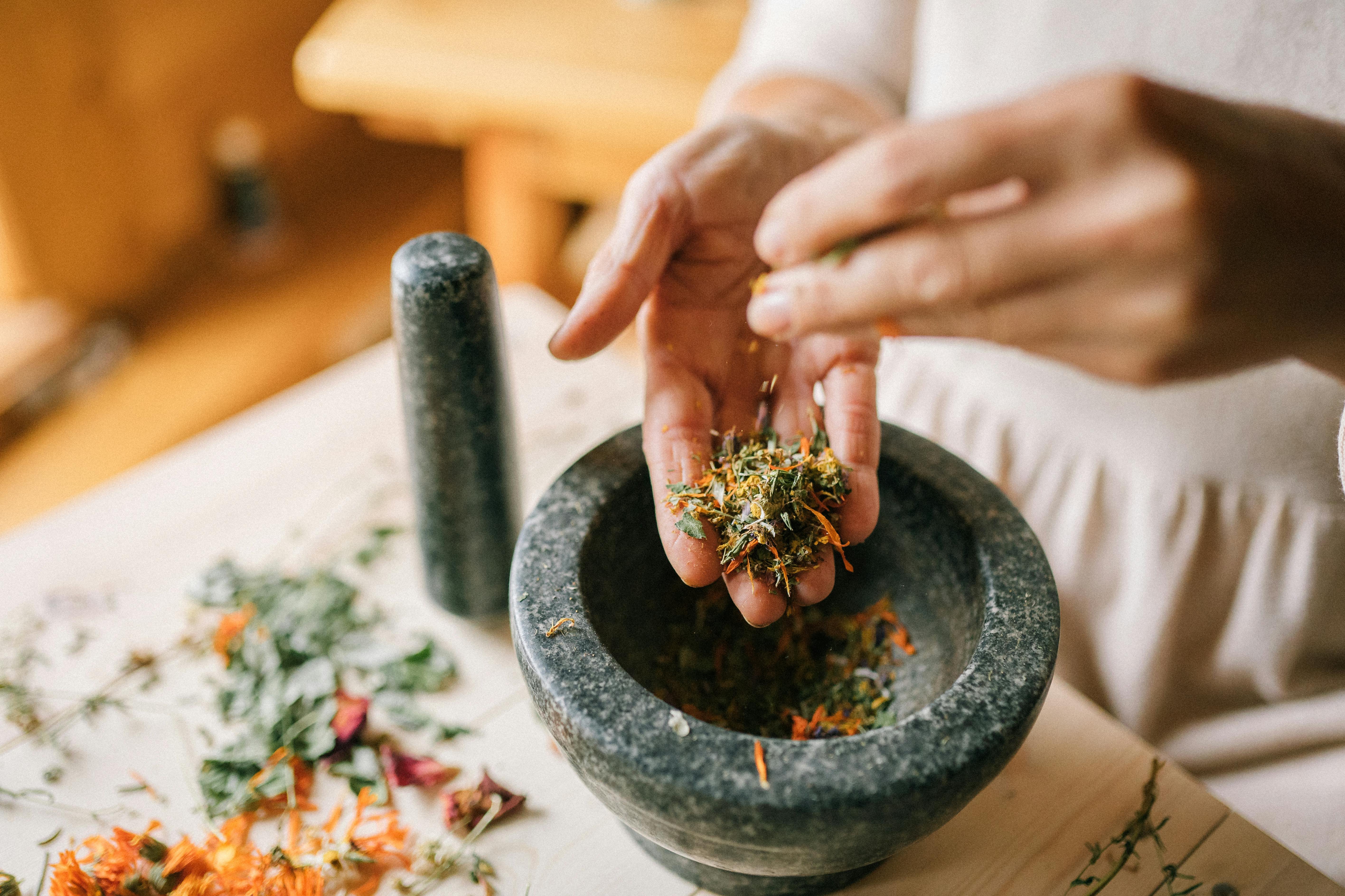 Hands using a mortar and pestle in a Thai village kitchen